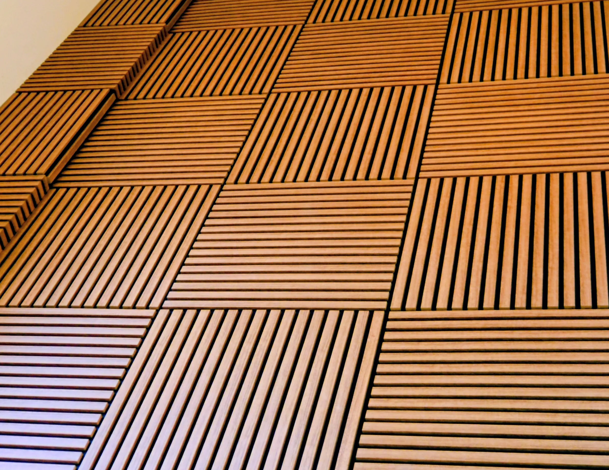 The panels seen along the wall, the slats catching the light one after another.