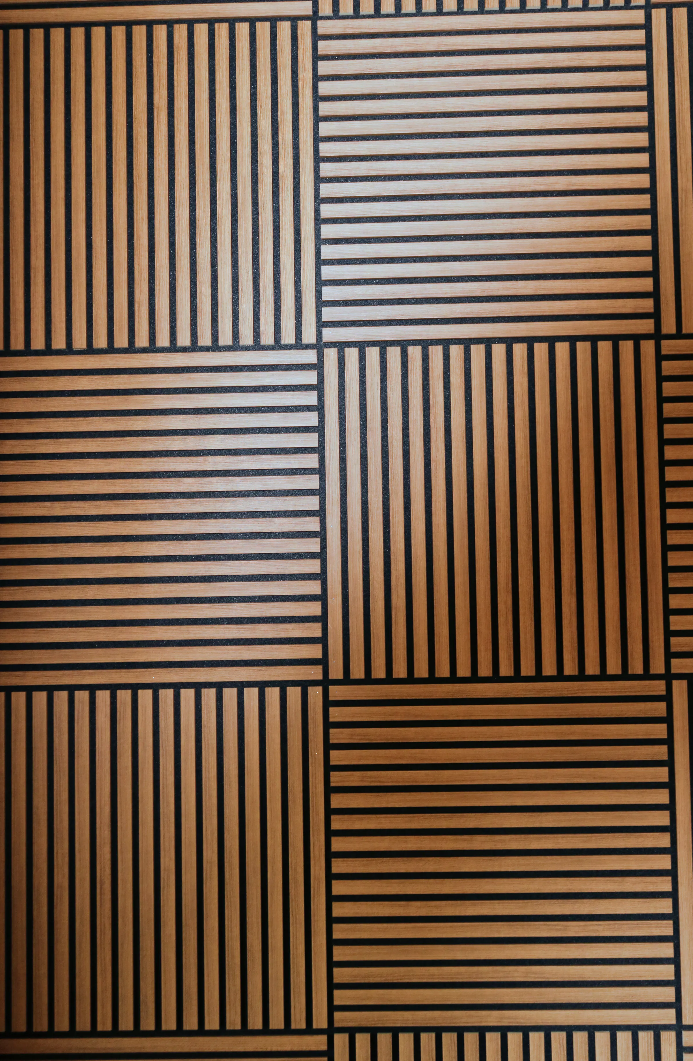 Wooden acoustic panels laid so the grooves of each square run against its neighbour, giving a woven look.
