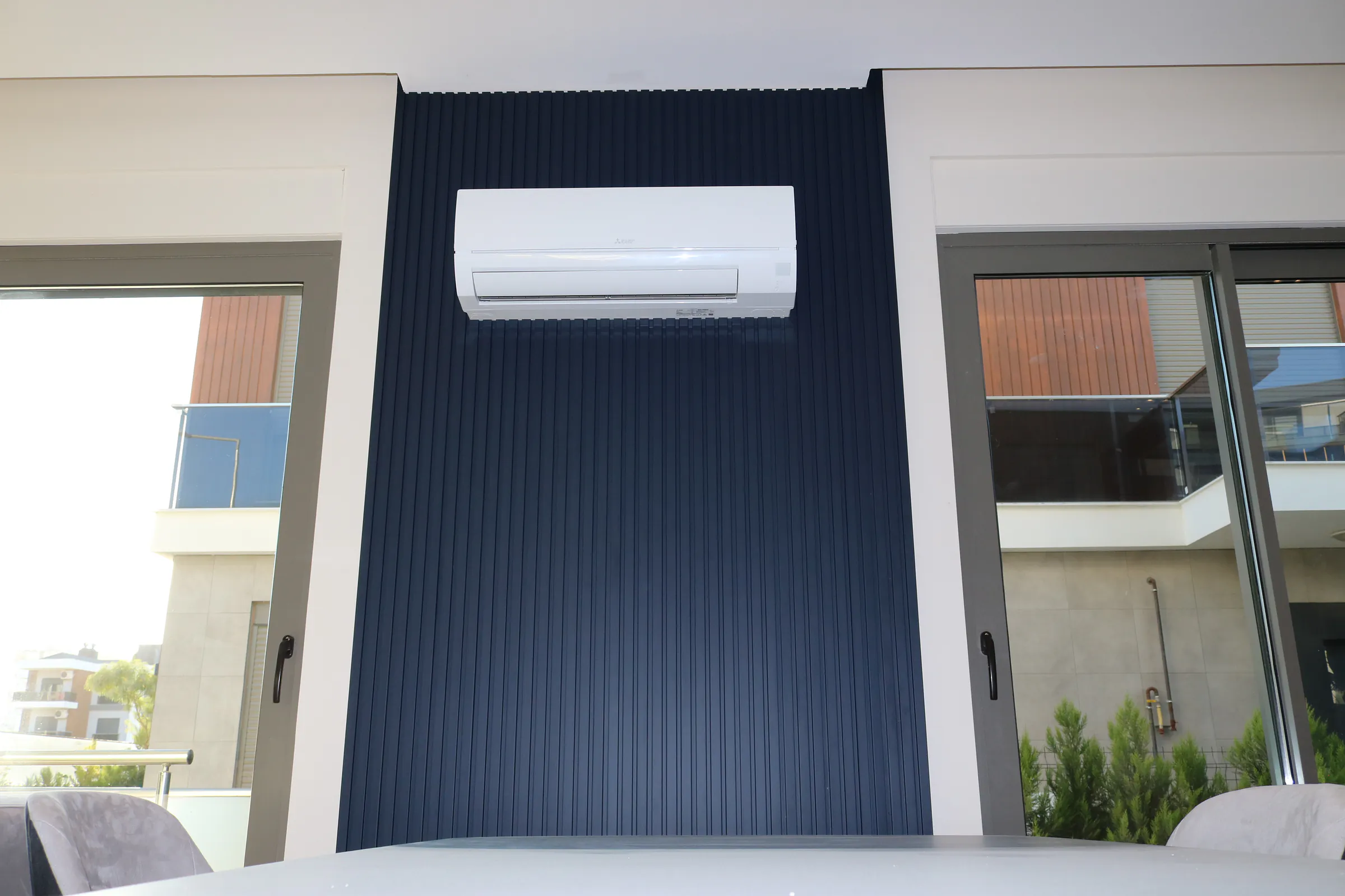A dark ribbed wall running the full height of the room, with the air conditioning set flush into it.