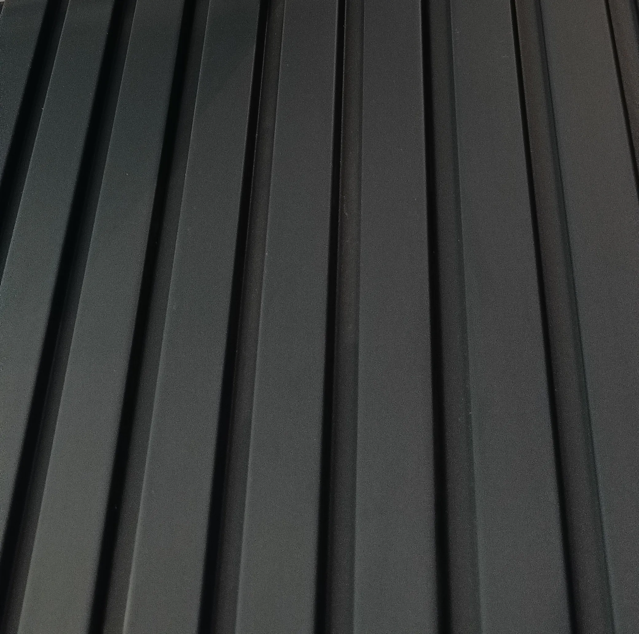 A close view of matt charcoal slats running the full height of a wall.