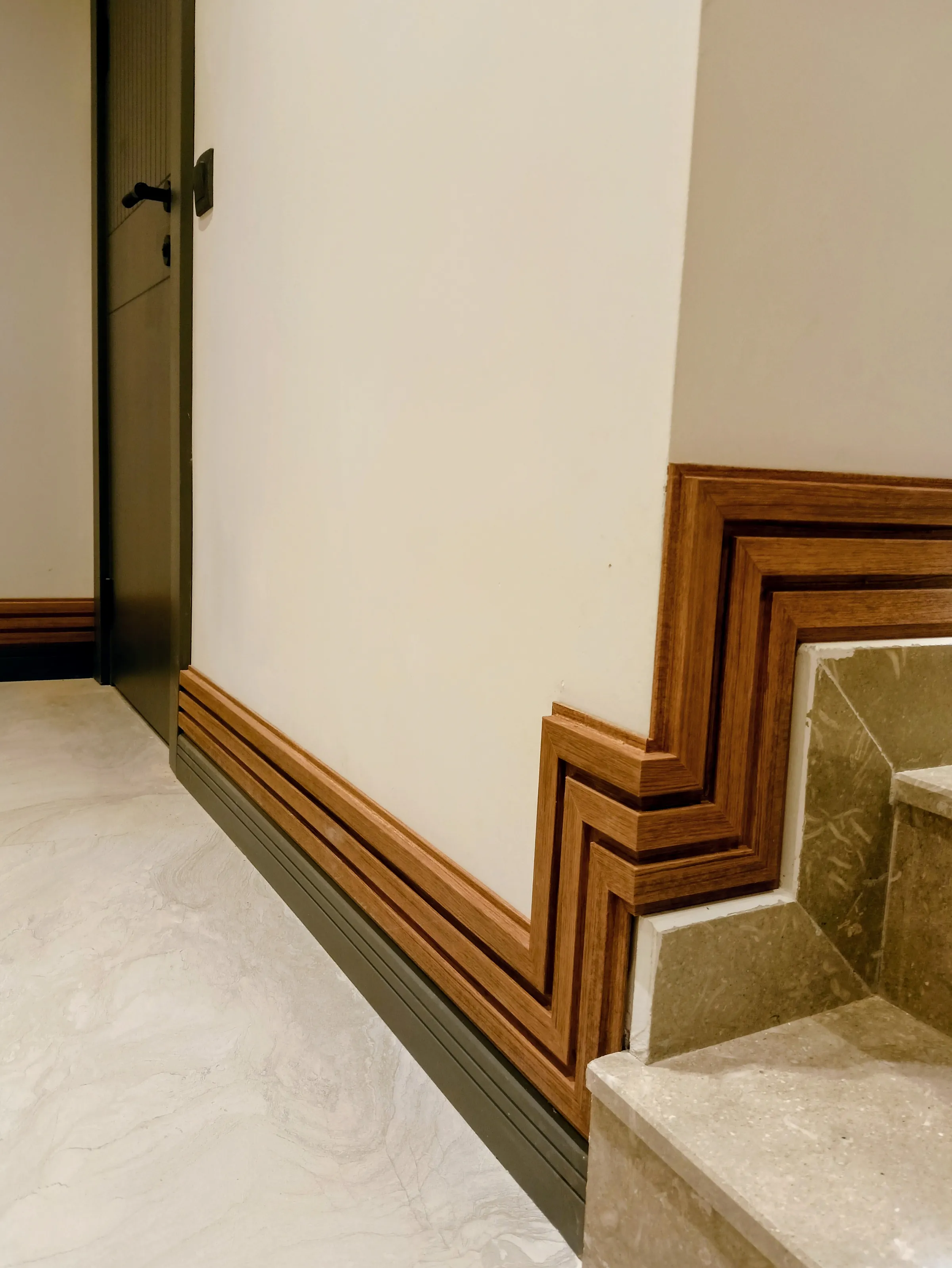Wooden trim following a staircase, cut to turn at every step.