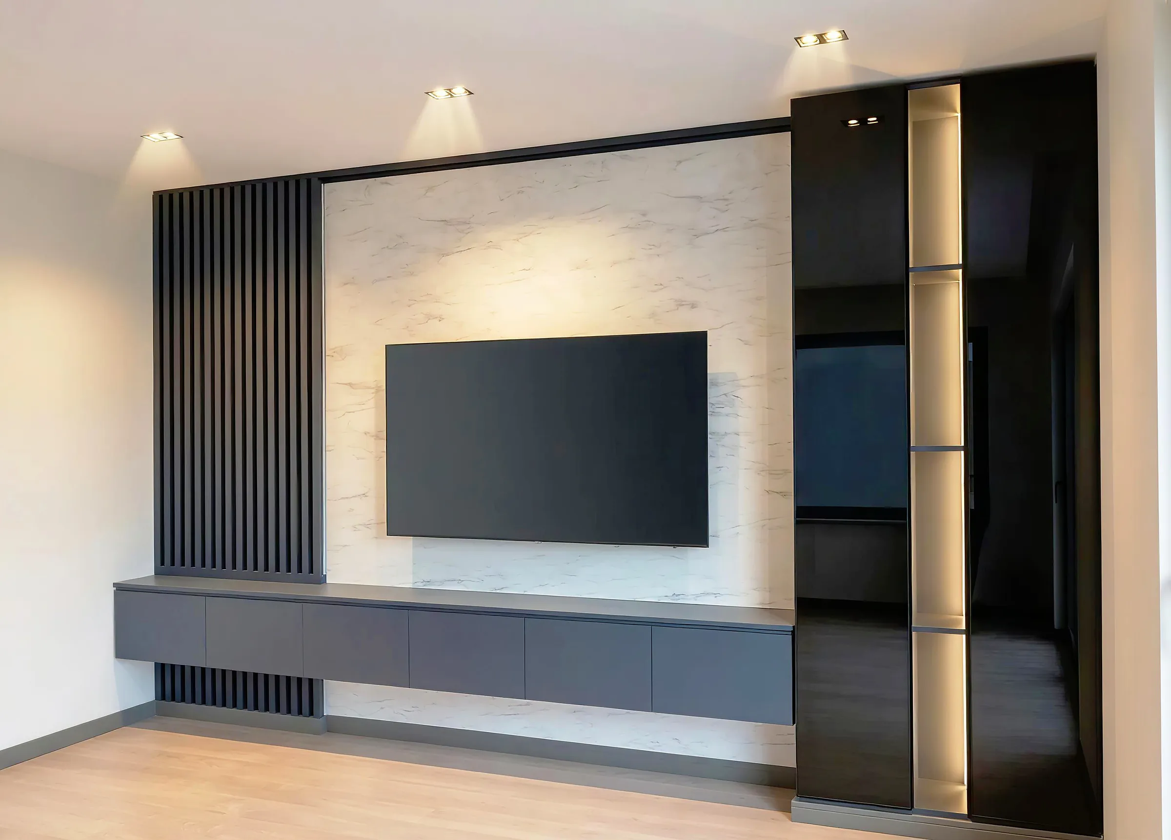 A television set into a stone wall above a built-in unit, with wood to one side.