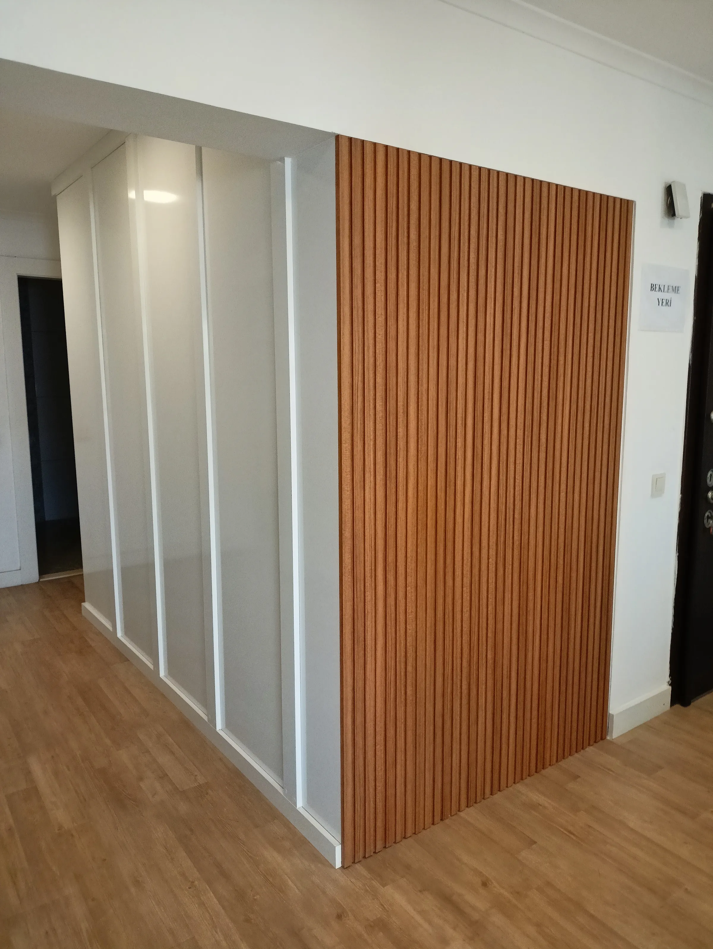 White and wooden panelling set side by side along a hallway.